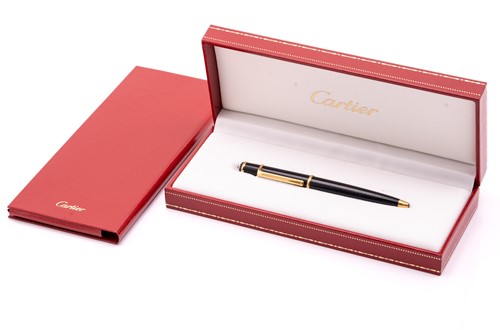 Lot 274 - A Cartier ballpoint pen, featuring black resin...