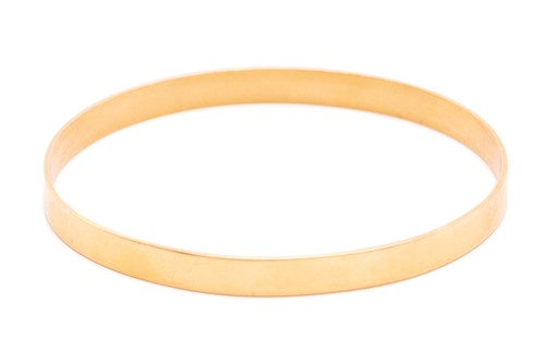 Lot 279 - A yellow metal closed bangle, with a solid...