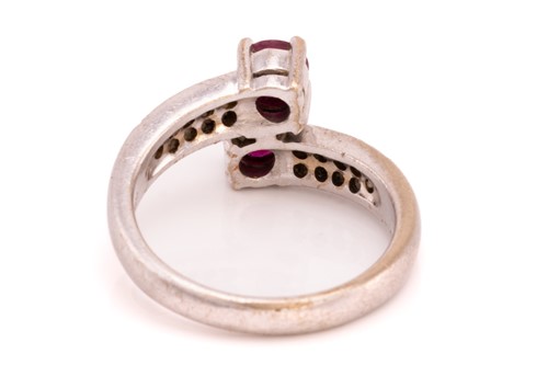 Lot 250 - A ruby and diamond crossover ring, featuring...