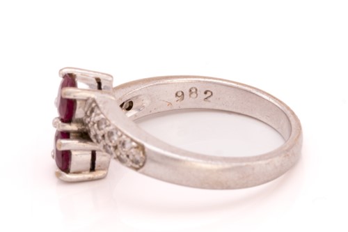 Lot 250 - A ruby and diamond crossover ring, featuring...