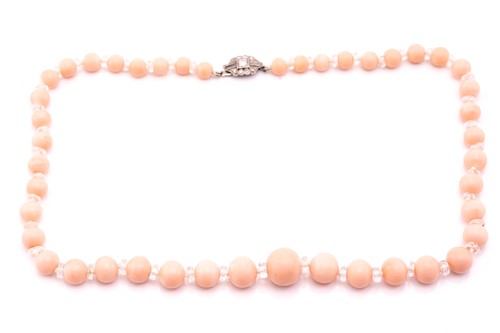 Lot 67 - A pink coral bead necklace with a diamond-set...