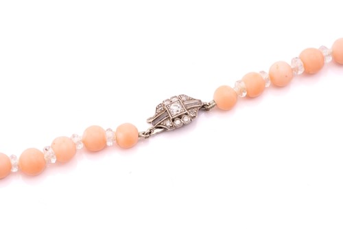 Lot 67 - A pink coral bead necklace with a diamond-set...