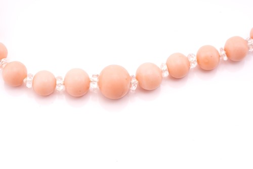 Lot 67 - A pink coral bead necklace with a diamond-set...