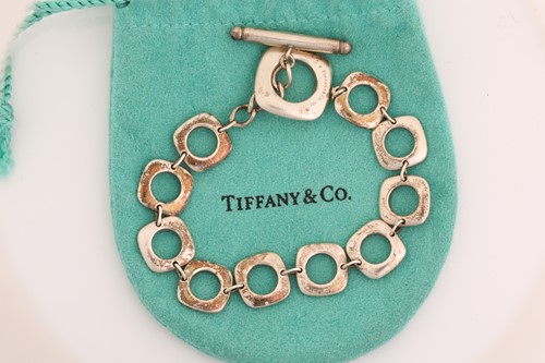 Lot 318 - Tiffany & Co. - a square cushion link bracelet,...