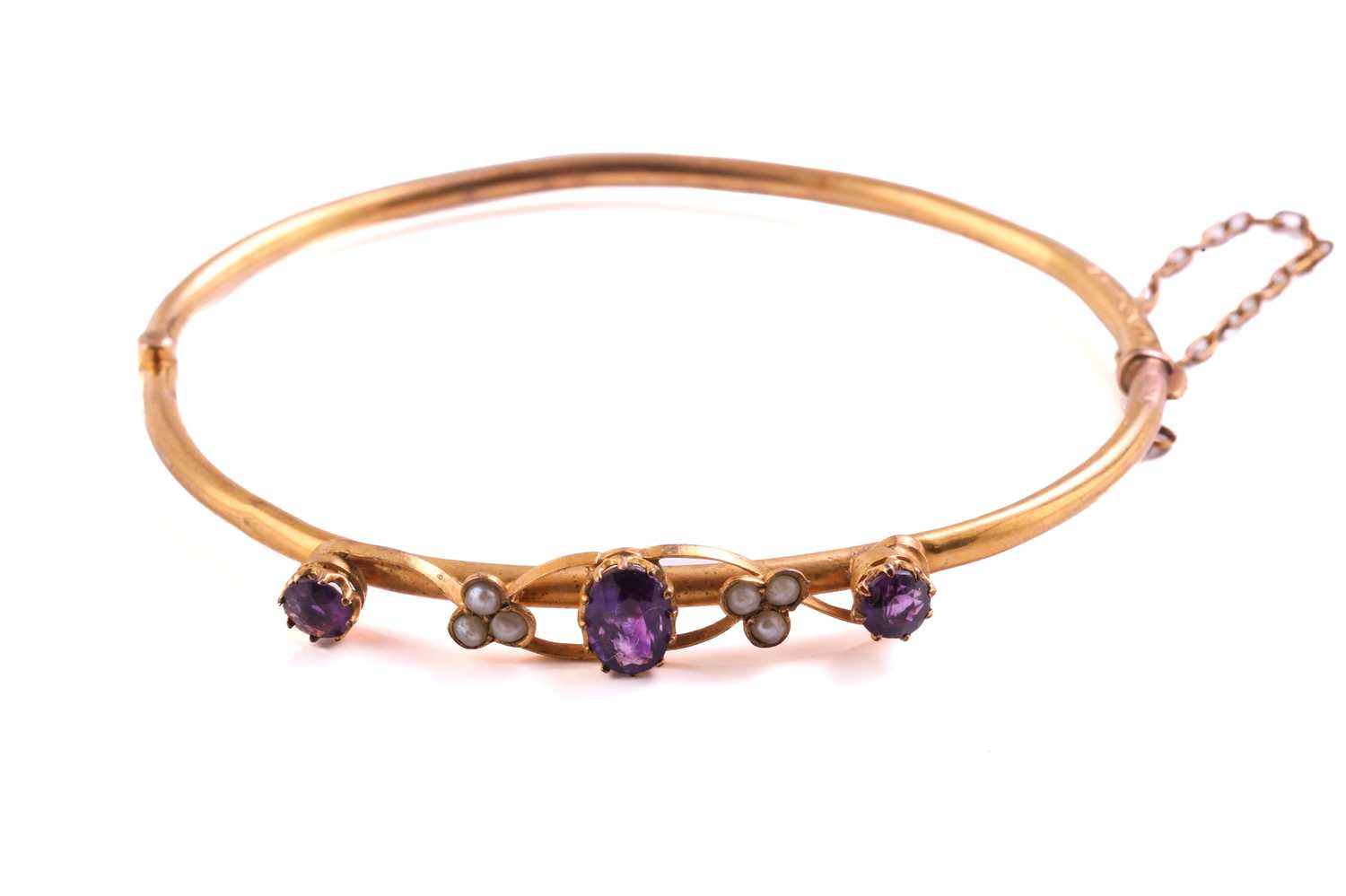 Lot 51 - An Edwardian 9ct yellow gold bangle, mounted...