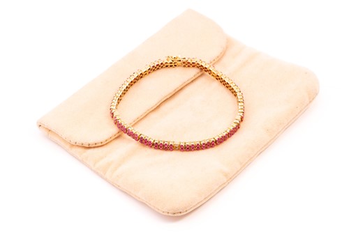 Lot 162 - A yellow metal, ruby and diamond line bracelet;...