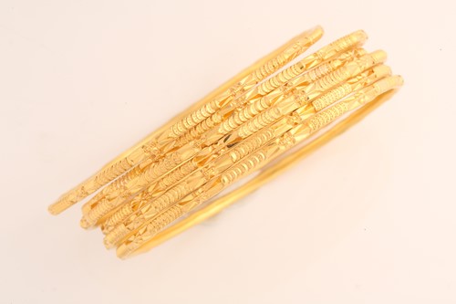 Lot 141 - A suite of six yellow metal bangles, in...