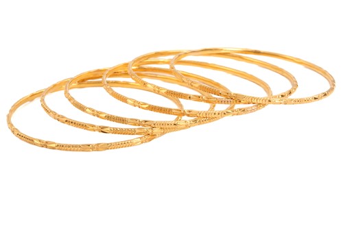 Lot 141 - A suite of six yellow metal bangles, in...