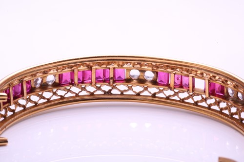 Lot 87 - A hinged bangle set with synthetic ruby and...