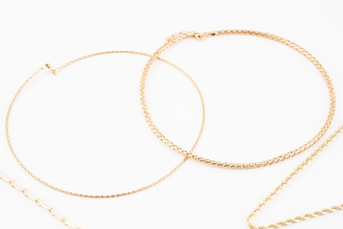 Lot 100 - A group of five yellow gold necklaces;...