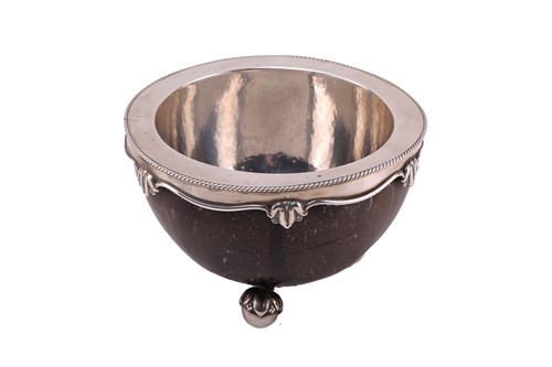 Lot 465 - A late Arts & Crafts silver mounted coconut...