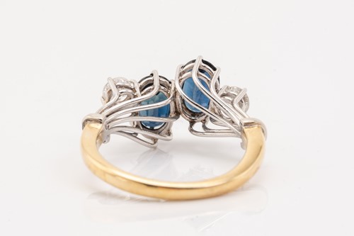 Lot 125 - A two stone sapphire and diamond ring; the...