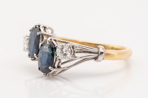 Lot 125 - A two stone sapphire and diamond ring; the...