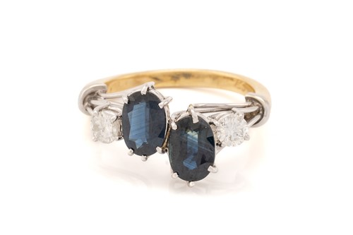Lot 125 - A two stone sapphire and diamond ring; the...