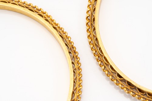 Lot 77 - A pair of high-carat gold closed bangles, with...