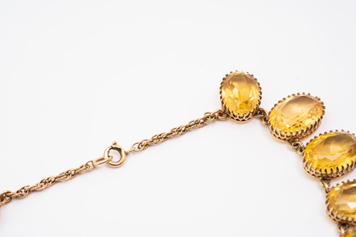 Lot 197 - A yellow metal and citrine rivière necklace,...