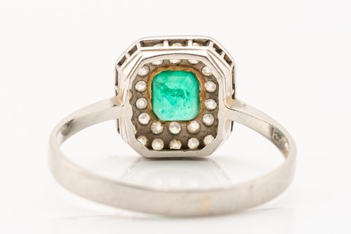 Lot 51 - An emerald and diamond cluster ring in...