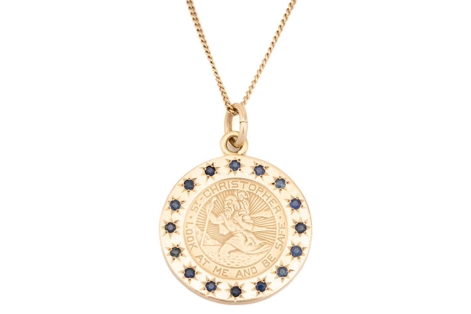 Lot 26 - A St. Christopher medal with sapphire surround...