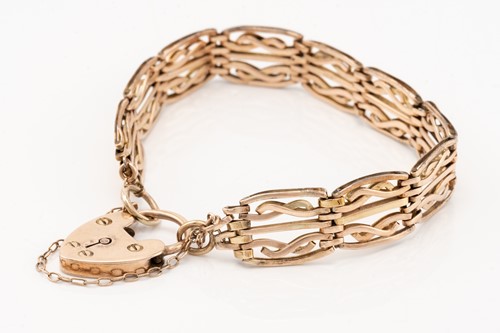 Lot 221 - A rose gold knot bangle; the hinged hollow...