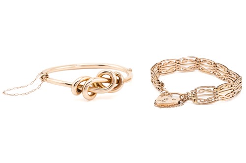 Lot 221 - A rose gold knot bangle; the hinged hollow...