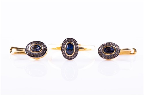 Lot 432 - A diamond and sapphire oval cluster ring set...