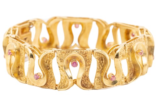 Lot 94 - An 18ct gold and ruby bracelet; composed of...