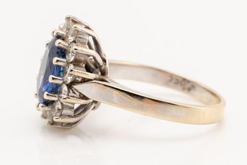 Lot 68 - A sapphire and diamond cluster ring; the oval...