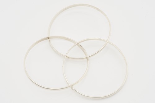 Lot 524 - A group of eleven silver trilogy bangles,...