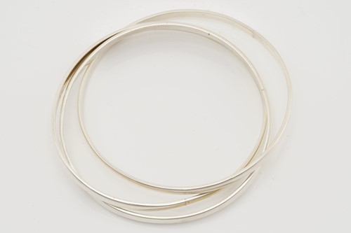 Lot 524 - A group of eleven silver trilogy bangles,...