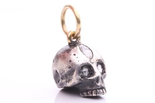 Lot 44 - A diamond-set skull charm pendant in silver...
