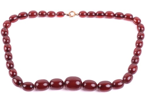 Lot 37 - A single-strand graduated amber bead necklace,...