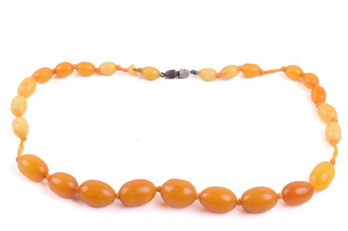 Lot 37 - A single-strand graduated amber bead necklace,...