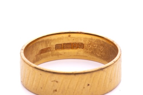 Lot 19 - A wedding band in 22ct yellow gold, with a...