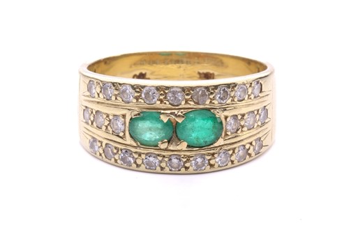 Lot 102 - An emerald and diamond ring set with two...