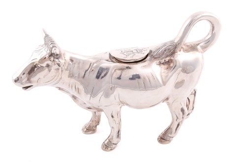 Lot 420 - A cow creamer of conventional form, the hinged...