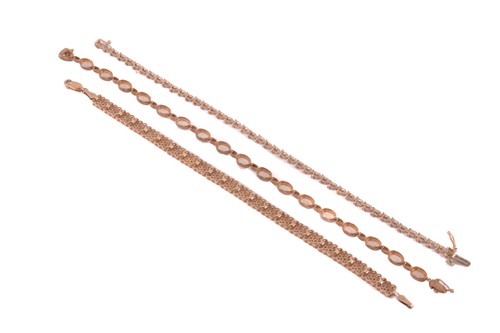 Lot 20 - Three gem-set line bracelets in 9ct gold; the...
