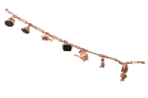 Lot 62 - A 9ct rose gold watch chain with charms,...