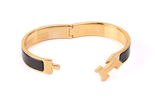 Lot 140 - Hermès - A narrow 'Clic H' bracelet with black...