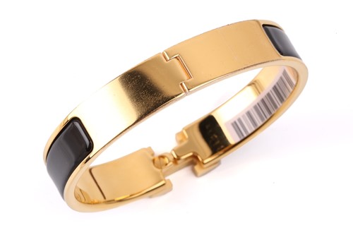 Lot 140 - Hermès - A narrow 'Clic H' bracelet with black...