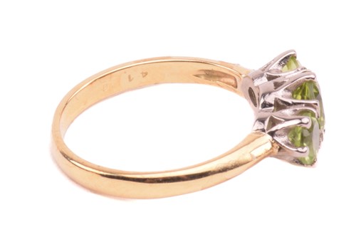 Lot 66 - A three-stone peridot ring in 18ct gold,...