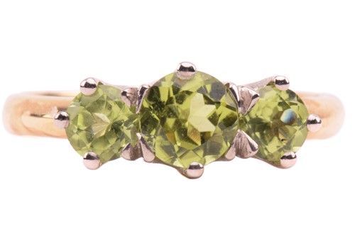 Lot 66 - A three-stone peridot ring in 18ct gold,...