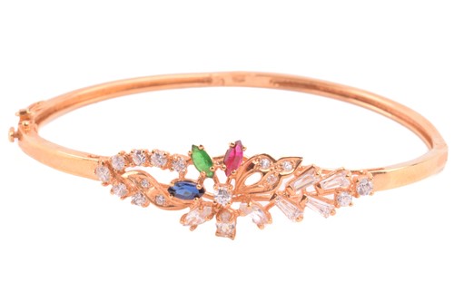 Lot 104 - A floral spray bangle set with cubic zirconia,...