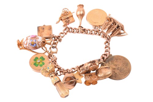 Lot 82 - A charm bracelet in 9ct rose gold, consisting...