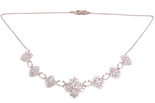 Lot 201 - A diamond cluster necklace, set with an...