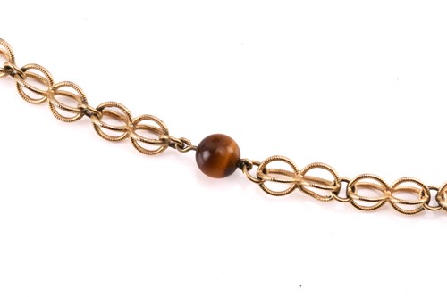 Lot 64 - A cage link necklace with tiger's eye bead...