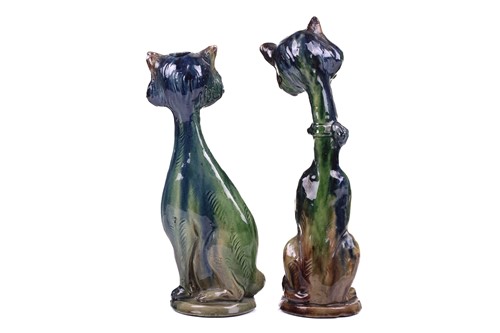 Lot 244 - A pair of earthenware winking cat candlesticks,...