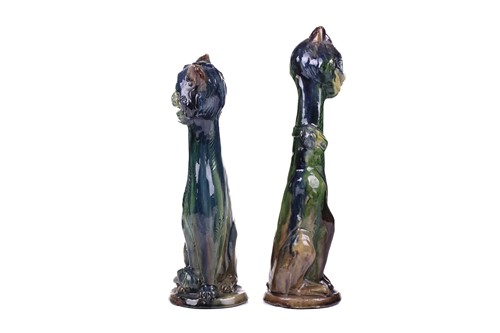 Lot 244 - A pair of earthenware winking cat candlesticks,...
