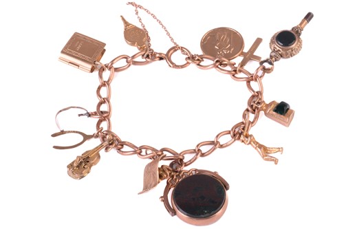 Lot 175 - A charm bracelet marked '375' to each link,...