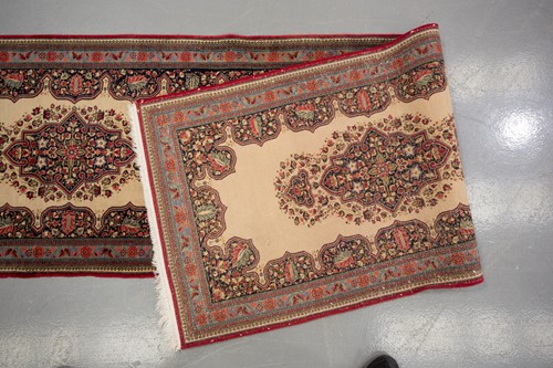 Lot 155 - An ivory ground Kerman strip runner with three...
