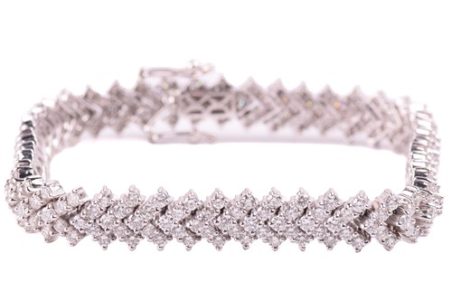 Lot 245 - A diamond chevron line bracelet, set with...